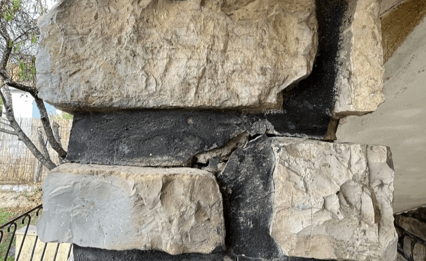 Acheteur hésitant devant une maison ancienne présentant des fissures.